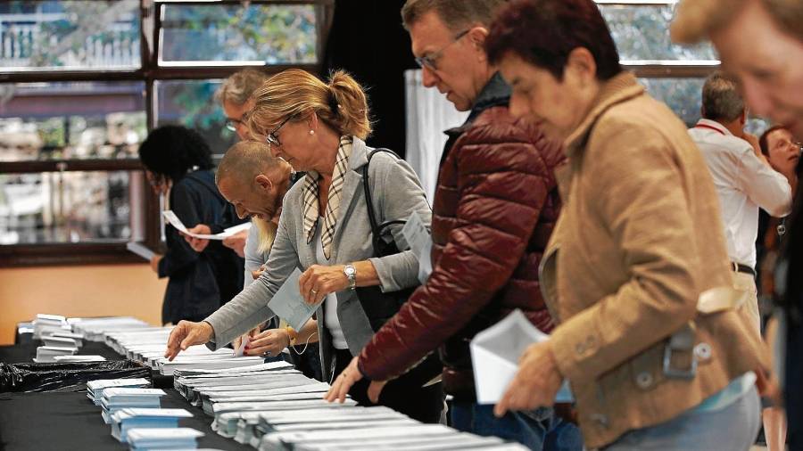 Varios ciudadanos escogen sus papeletas electorales en los comicios del pasado domingo para las elecciones europeas y municipales. FOTO: EFE