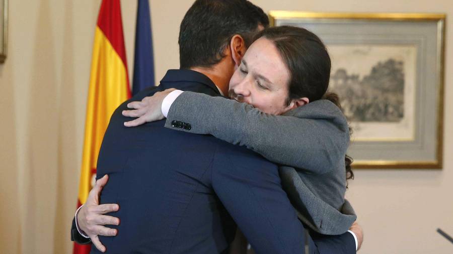 El presidente del Gobierno en funciones, Pedro Sánchez., y el líder de Unidas Podemos, Pablo Iglesias, se abrazan en el Congreso de los Diputados donde hoy han firmado un acuerdo para la formación de un Ejecutivo en España