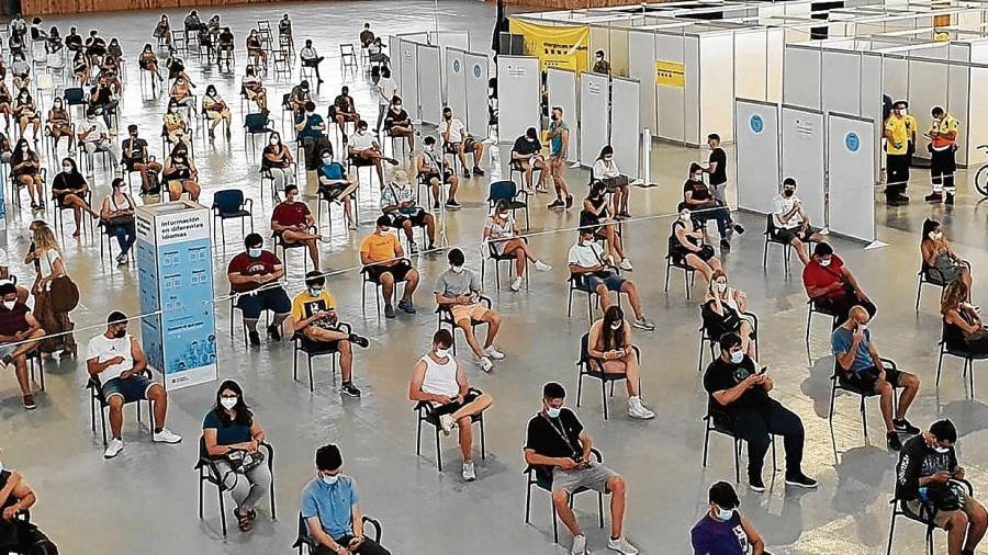 Personas recién vacunadas esperan tras el pinchazo en los asientos del Palau d’Esports de la Anella Mediterrània, en Campclar. Foto: Salut
