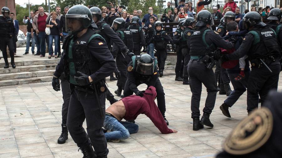 Agents de la Guàrdia Civil desallotgen alguns dels manifestants que s'havien assegut al terra per impedir l'accés al col·legi de Sant Julià de Ramis. FOTO: ACN