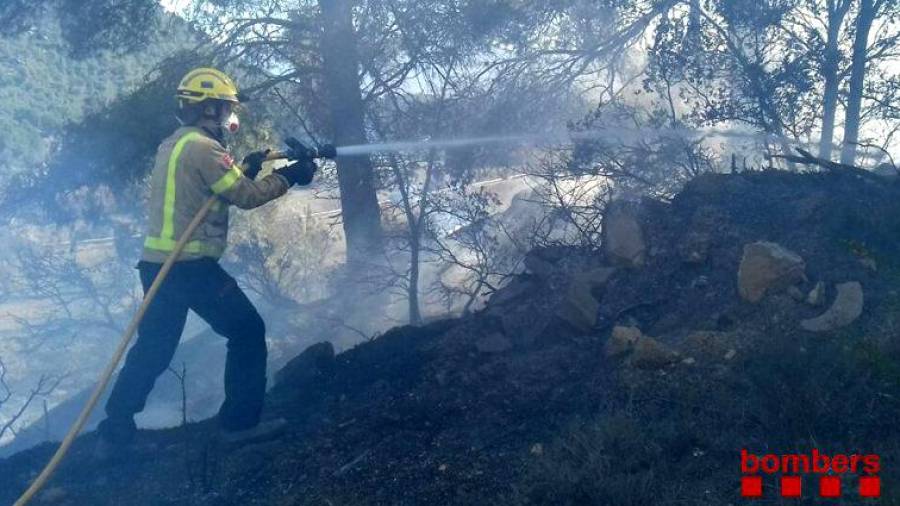 Imagen de uno de los bomberos apagando el fuego en Solivella. FOTO: Bombers