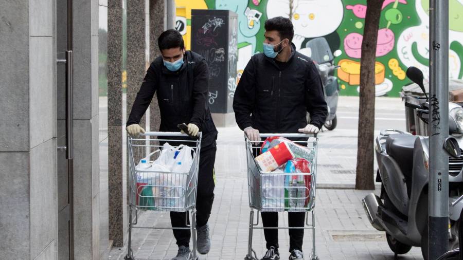 Imagen de dos jóvenes volviendo de la compra. EFE
