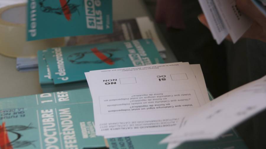 Pla detall de les paperetes pel referèndum de l’1-O que es repartien aquest diumenge en una parada d’estudiants davant de les portes de la Universitat de Barcelona. Foto: ACN