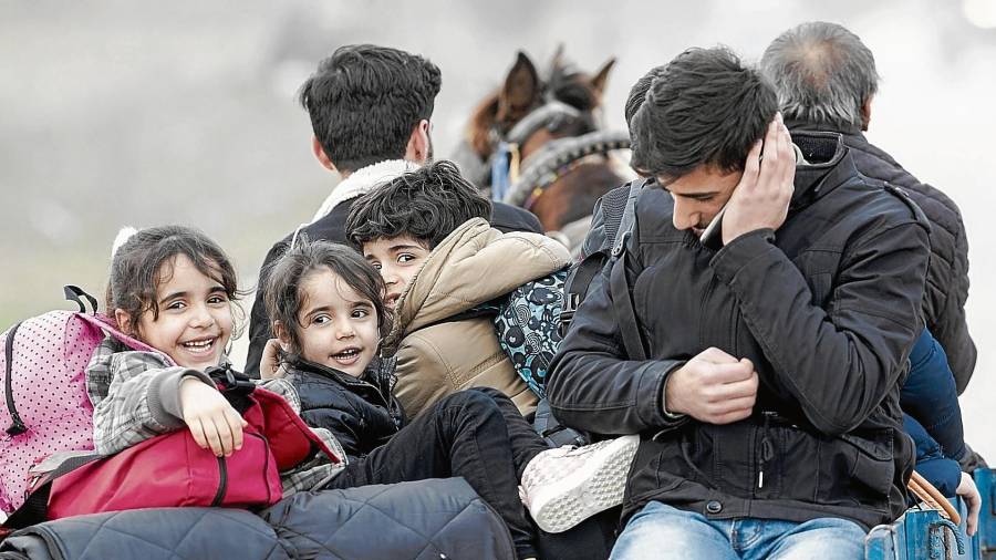 Una familia con niños se dirige hacia la frontera griega cerca de Pazarkule, en Edirne, Turquía, ayer. FOTO: tolga bozoglu/efe