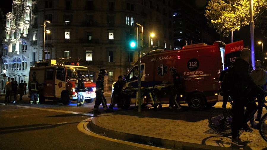 Una ambulancia y un vehículo sanitario de los bomberos atienden a un herido durante los disturbios de este jueves 17 de octubre en la confluencia del Paseo de Gracia con Aragón. FOTO. ACN
