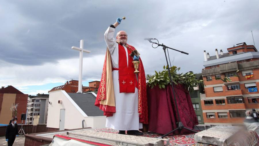 Imagen de un párroco en Oviedo bendiciendo a los feligreses desde la azotea de su Iglesia. EFE