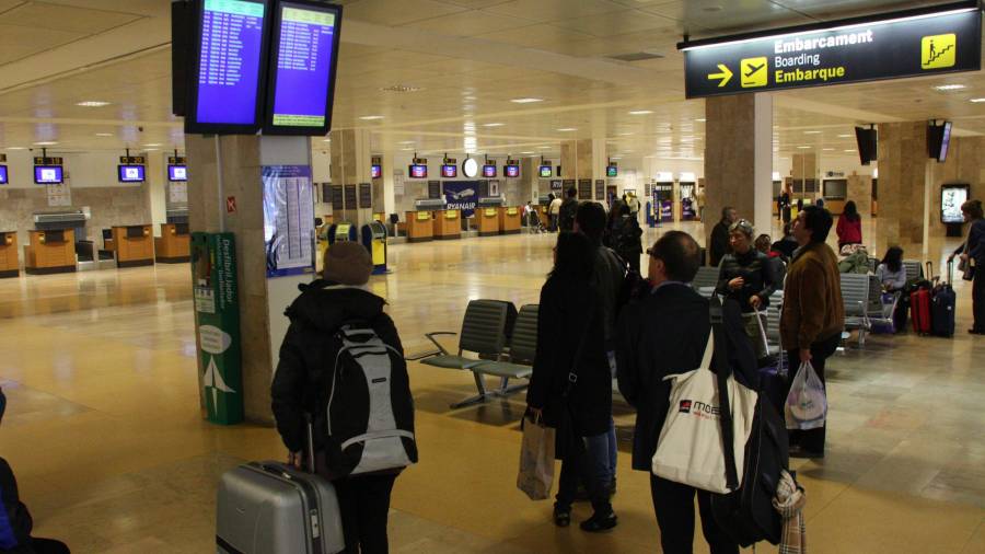 Passatgers fent cua per facturar la seva maleta al mostrador de Ryanair, abans d'agafar un dels vols que la companyia de baix cost irlandesa opera des de l'aeroport de Girona. FOTO: ACN