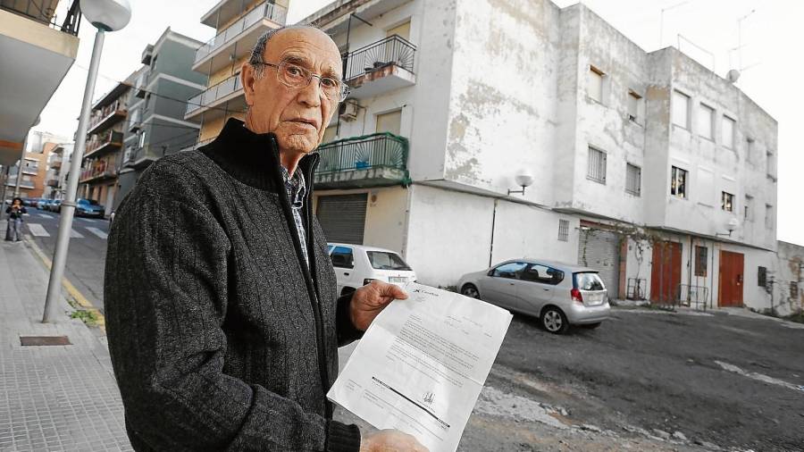 Francisco Casas, delante de su casa, totalmente apuntalada, mostrando la documentación presentada en el Ayuntamiento.