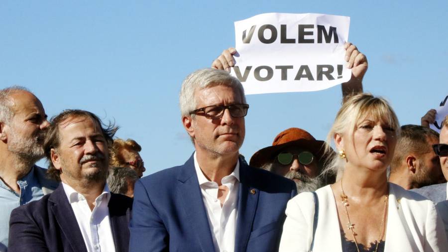 Pla mig de l'alcalde de Tarragona, Josep Fèlix Ballesteros, amb els regidors Pau Pérez i Elvira Ferrando, amb una pancarta de 'Volem votar' al seu darrere. Foto: ACN