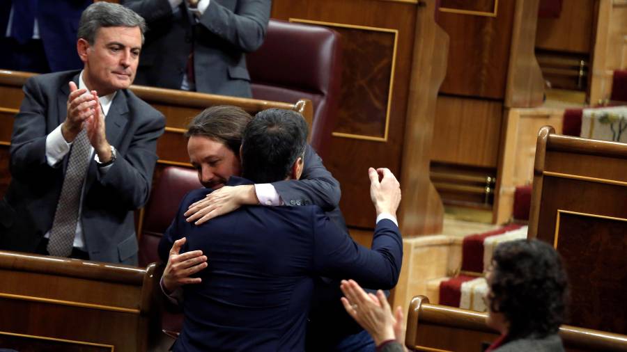 El candidato a presidente, Pedro Sánchez, y el líder de Podemos, Pablo Iglesias, se abrazan ayer. FOTO: EFE