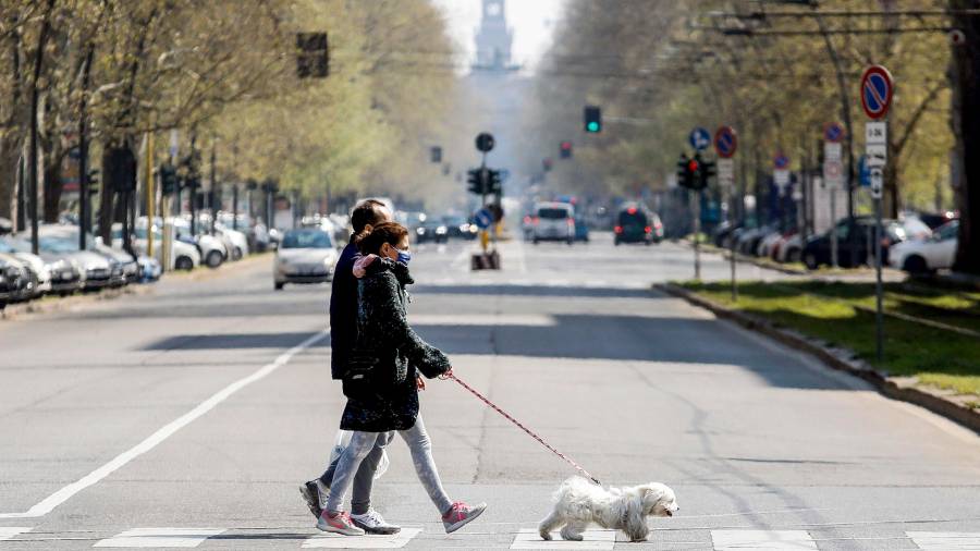 Una pareja paseando a su masecota en Milán. Foto: EFE