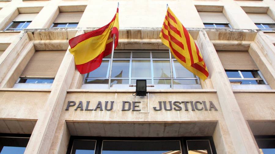 Pla contrapicat de la façana d'entrada a l'Audiència de Tarragona, amb el rètol de 'Palau de Justícia' i les banderes espanyola i catalana. FOTO: ACN