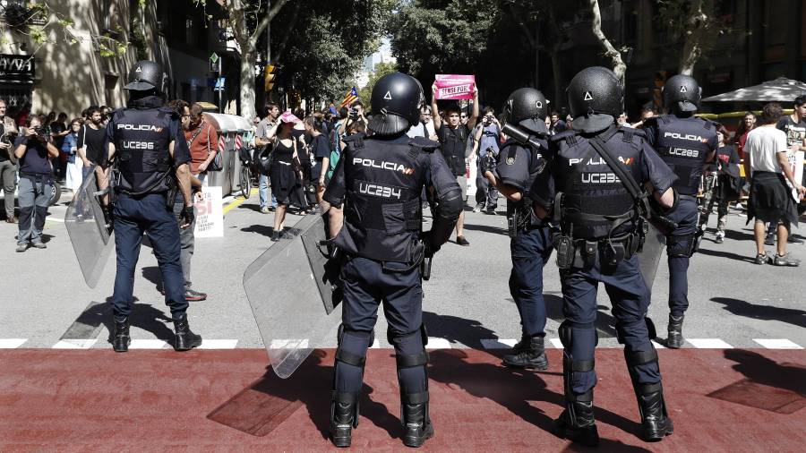 Un millar de simpatizantes de la CUP permanecen concentrados desde el mediodía ante la sede central de esta formación en Barcelona, para tratar de evitar el posible registro del local por parte de los efectivos de la Policía Nacional