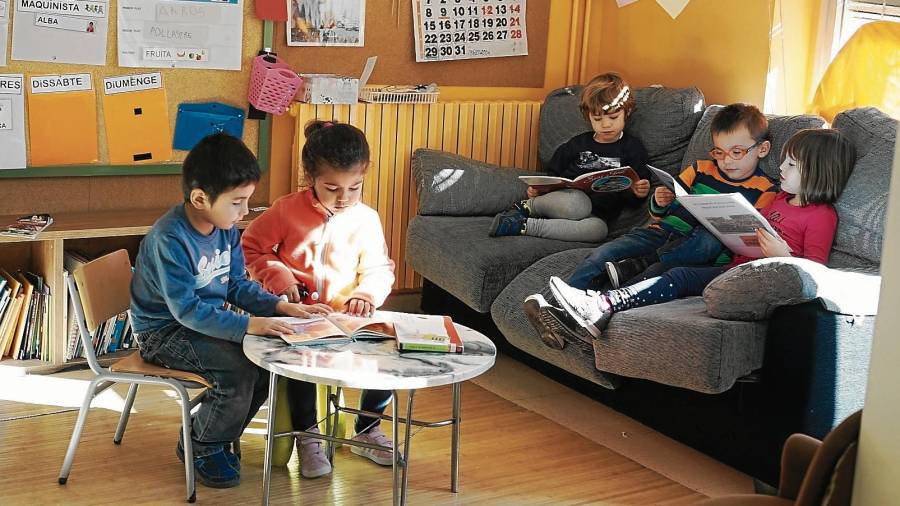 Els nens de 3 a 5 anys llegint contes a la seva classe durant l’hora d’esbarjo, a l’escola de la Riba. FOTO: alba tudó