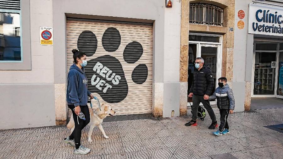 Una chica con un perro pasea por Reus, junto a un menor. FOTO: ÀNGEL ULLATE