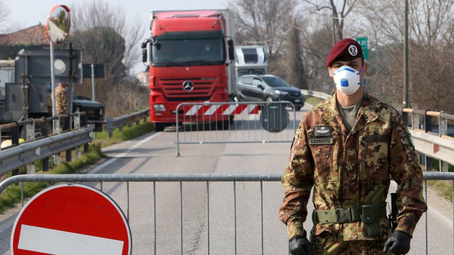 Un militar prohibiendo ayer el paso a la ciudad de Vo Euganeo, en el Véneto, donde se cree que se originó el segundo brote. FOTO: EFE