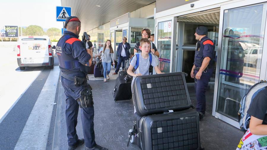 Grupos de turistas, a su llegada al Aeropuerto de Reus, donde se ha incrementado la vigilancia policial. Foto: Alba Mariné