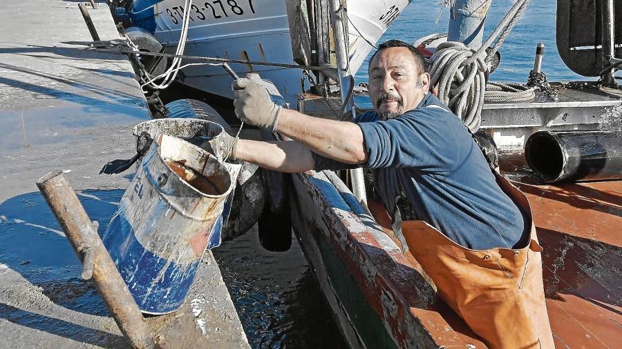 Ramon, saliendo de la embarcación con dos bidones de metal que se encontró durante su jornada laboral. FOTO: Alfredo González