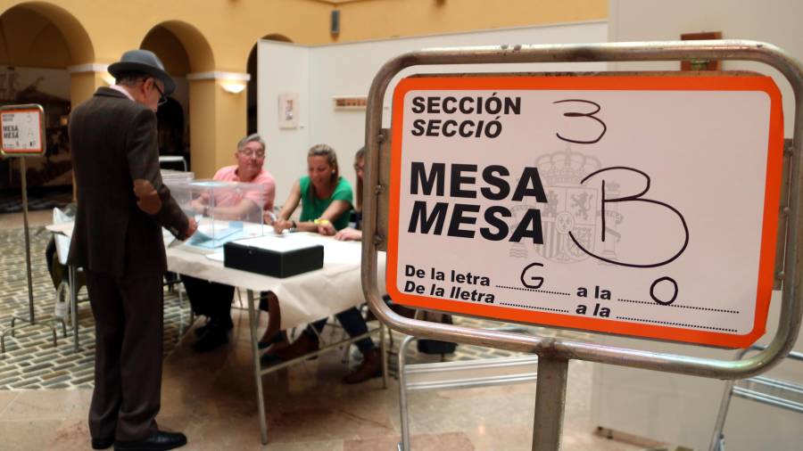 Un cartel indicativo y un votante en uno de los colegios electorales de la ciudad de Tarragona. FOTO: ACN