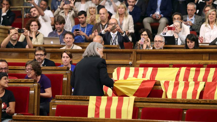 La diputada Àngels Martínez retira les banderes espanyoles dels escons del PP. EFE