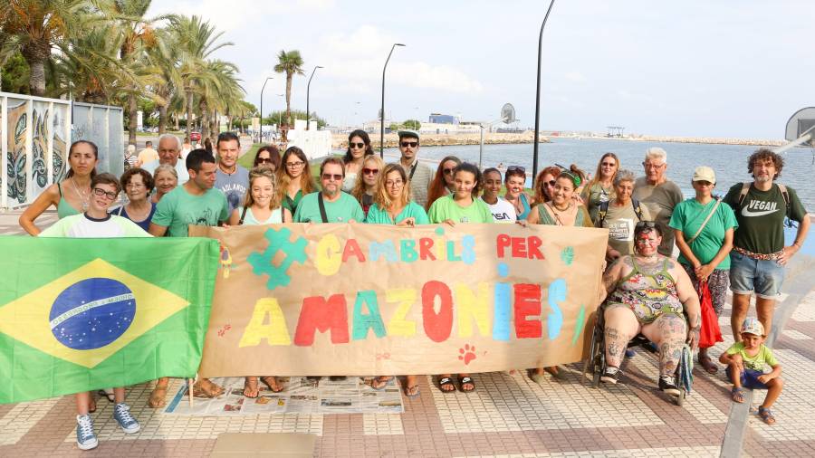El grupo de manifestantes posa con el cartel antes de iniciar la marcha hasta el Club Nàutic Cambrils. Foto: Alba Mariné