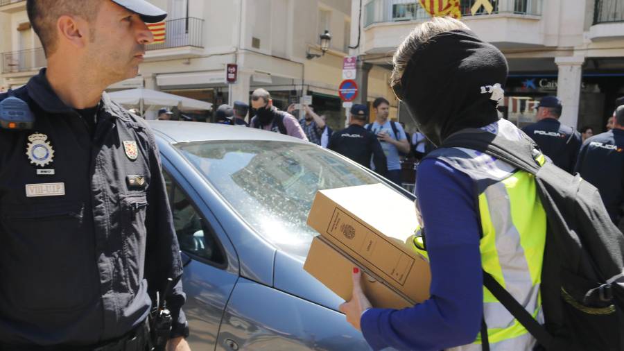 Un agente de la UDEF llevando documentación de CATmón de Reus al coche. FOTO: ACN