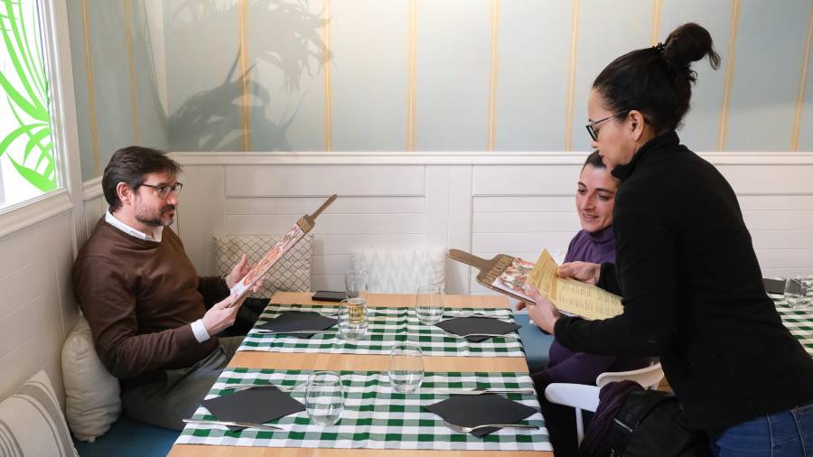 Una camarera ofrece el menú diario a dos clientes del restaurante reusense Batticuore. FOTO: Fabián Acidres