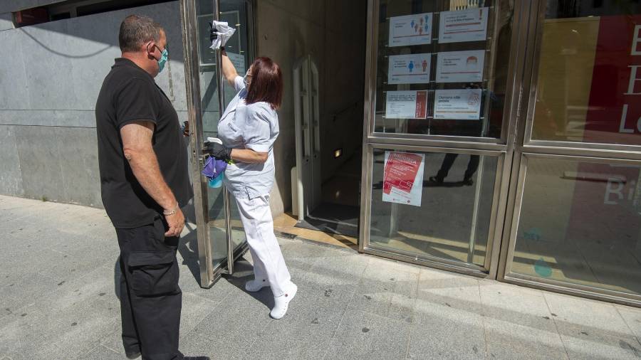 Una persona es troba a la porta per deixar passar d'un en un els usuaris, i una netejadora treballa sense descans per tot l'equipament. Foto: Joan Revillas