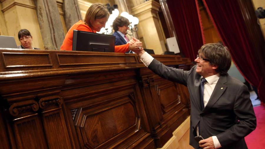 El presidente de la Generalitat Carles Puigdemont, saluda a la presidenta del Parlament Carme Forcadell