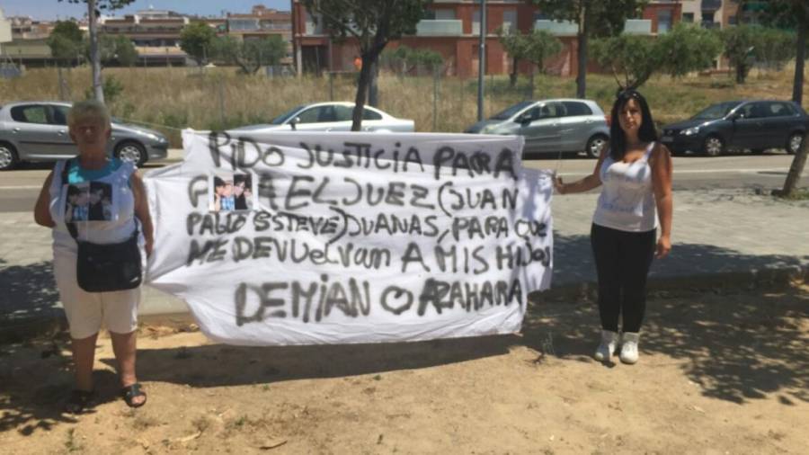 Aroa Sánchez y una familiar sostienen una pancarta que reclama que le devuelvan a sus hijos
