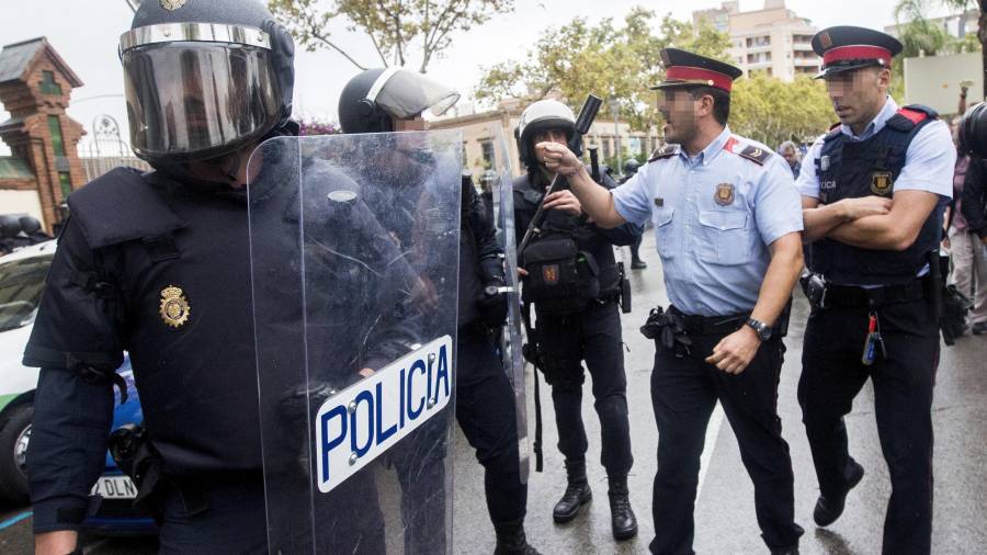 Agentes antidisturbios de la Policía Nacional y de los Mossos d' Esquadra discuten frente al Instituto Can Vilumara de L'Hospitalet de Llobregat. FOTO: EFE