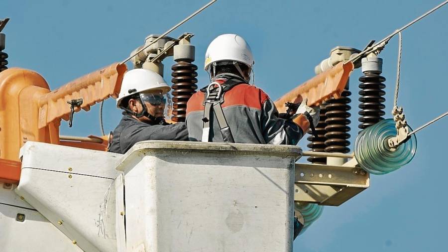 Tècnics reparant una línia elèctrica. FOTO: JOAN REVILLAS