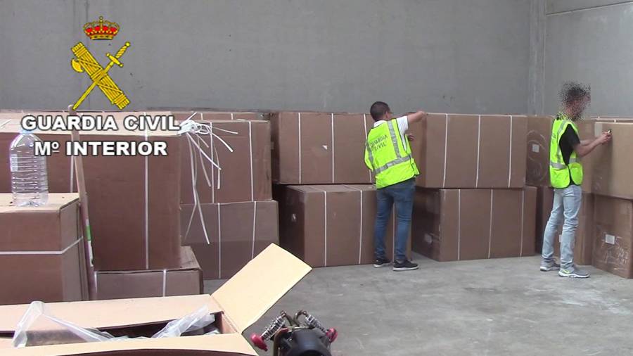 Agentes de la Guardia Civil revisan cajas en una de las naves.
