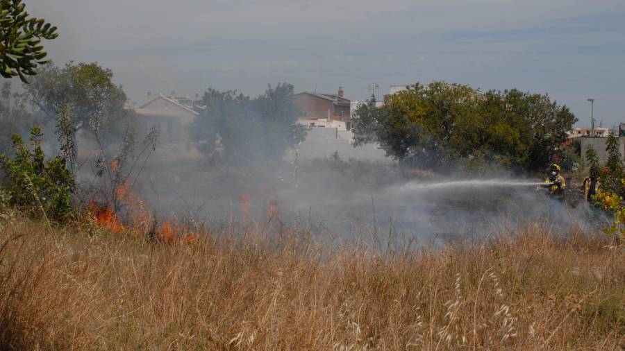 Los bomberos durante la extinción del incendio de hoy en La Canonja. Foto: Àngel Juanpere