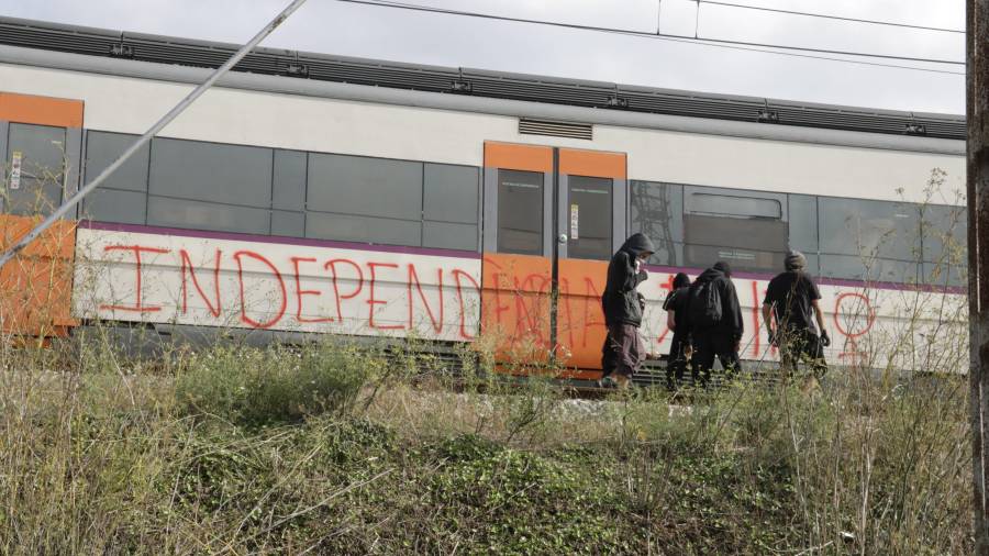 Imagen de archivo de un tren parado a la entrada de Girona con algunos manifestantes pintándolo con proclamas independentistas. FOTO: ACN