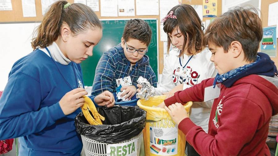 Alumnes de sisè de primària revisen cada setmana els tres contenidors de totes les classes de l’Escola Joan Ardèvol. FOTO: ALBA MARINÉ
