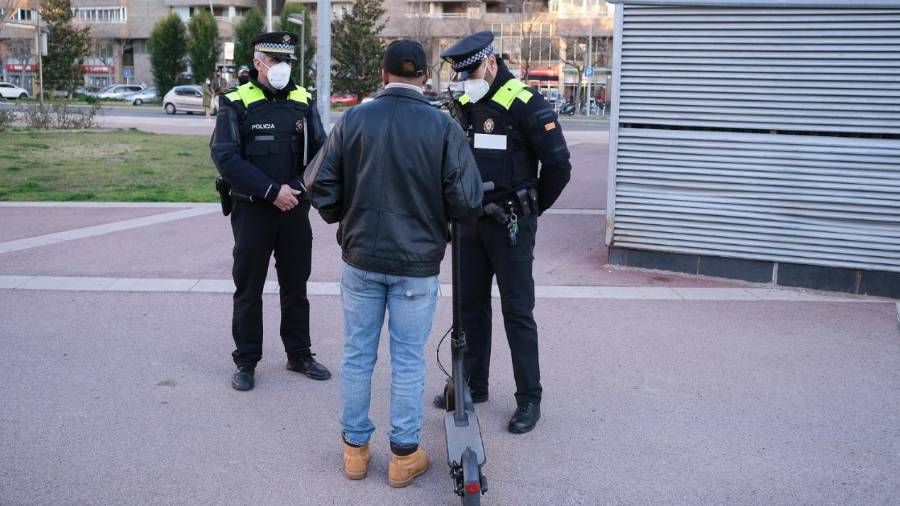 Dos agentes de la Guardia Urbana de Reus y un hombre con su patinete. FOTO: FABIÁN ACIDRES