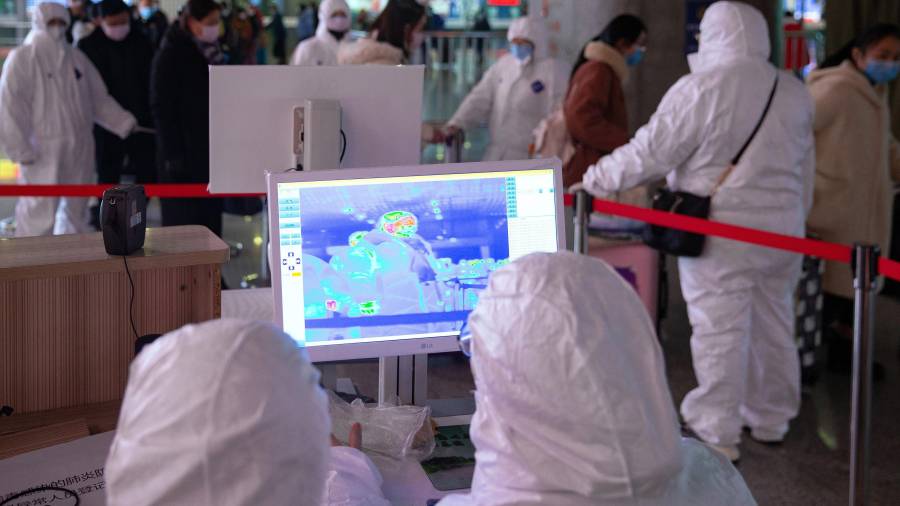 Médicos usando imágenes térmicas visibles en infrarrojos en el aeropuerto chino de Nanjing para ver la temperatura de los pasajeros. FOTO: EFE