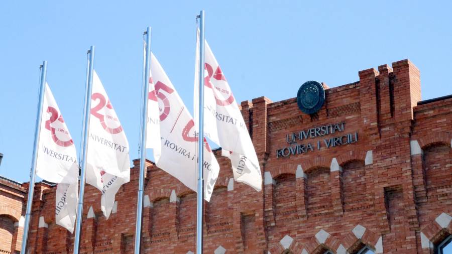 Pla detall de la façana del rectorat de la URV a Tarragona, amb la inscripció de la universitat i diverses banderes. Imatge de l'1 de juny del 2017.