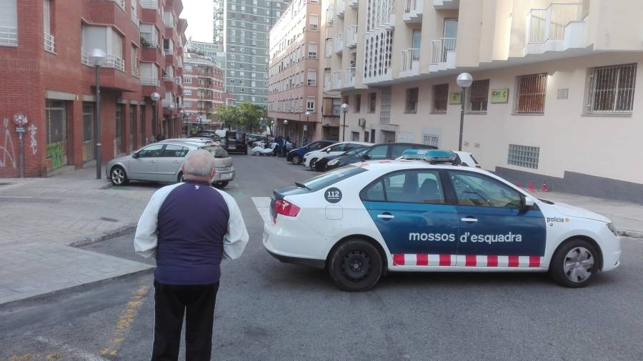 Un coche de Mossos corta la calle y al fondo el cadáver y el coche de la funeraria. FOTO: DT