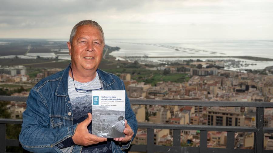 Pep Carcellé mostra el llibre amb la Ràpita i el Delta de fons. FOTO: Joan Revillas