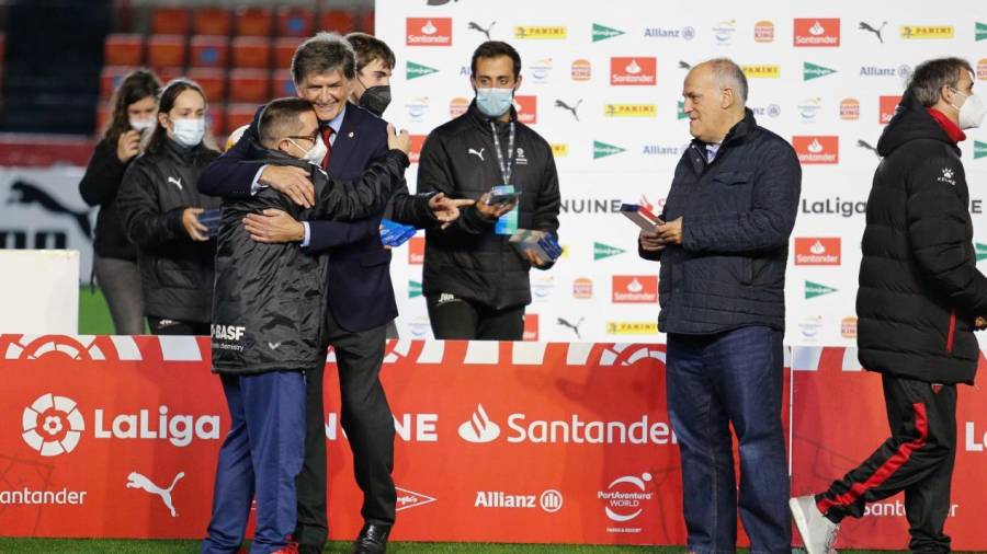 El capitán del Nàstic Genuine, Rubén Almazán, se abraza al presidente grana, Josep Maria Andreu, ante la atenta mirada de Javier Tegas, máximo responsable de LaLiga. FABIÁN ACIDRES