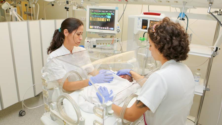 Ángela y Nerea, enfermera y auxiliar de la UCI de neonatos del Hospital Sant, en pleno trabajo. Foto: Alba Mariné