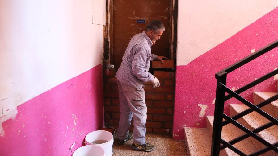 Un vecino de Mas Pellicer, en Reus, tapia un piso para protegerlo de la entrada de ocupas, un problema que asola al barrio. Foto: Alba Mariné