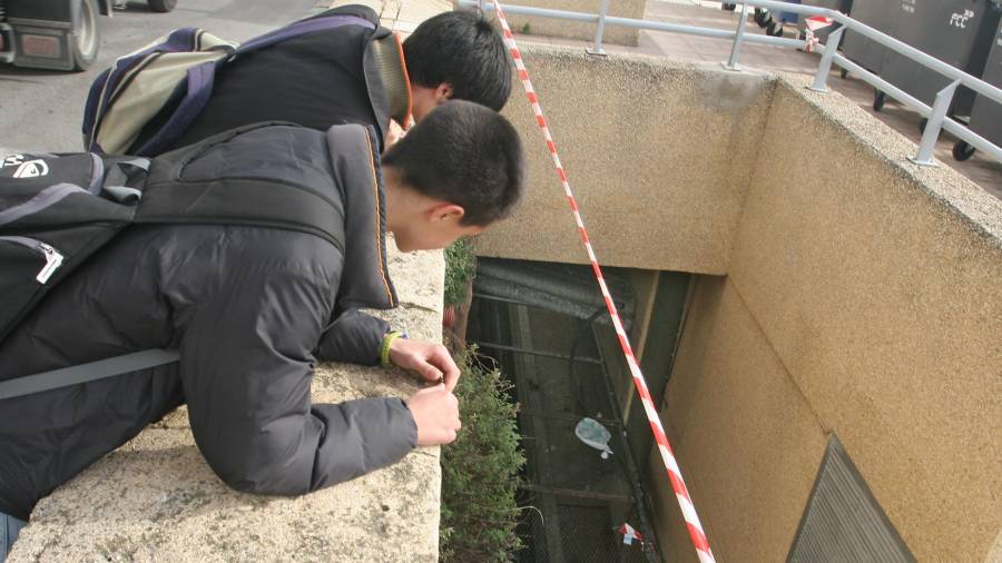 Dos jóvenes, en febrero de 2009, obervando el espacio por el que cayó el joven Jhon Edwar Claros. Foto: Txema Morera/Archivo Diari de Tarragona