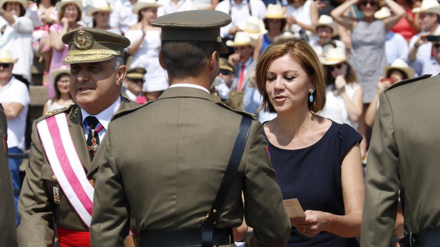 D'esquena un dels sergents, de cara, la ministra de defensa, Maria Dolores de Cospedal, fent entrega del despatx.