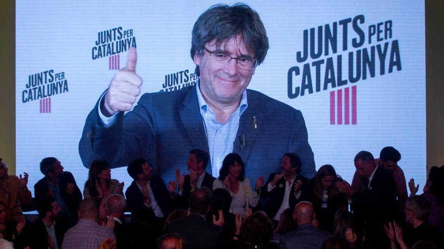 El expresidente de la Generalitat y cabeza de lista a las elecciones europeas por JxCat, Carles Puigdemont, interviene por videoconferencia en el acto de inicio de campaña en Barcelona. EFE/Quique García