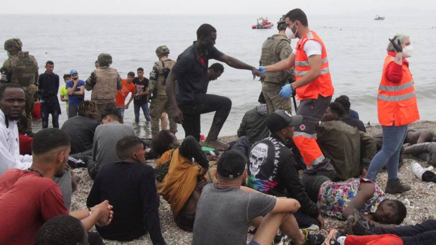Miembros del Ejército y la Cruz Roja ayudando a los inmigrantes llegados a Ceuta. EFE