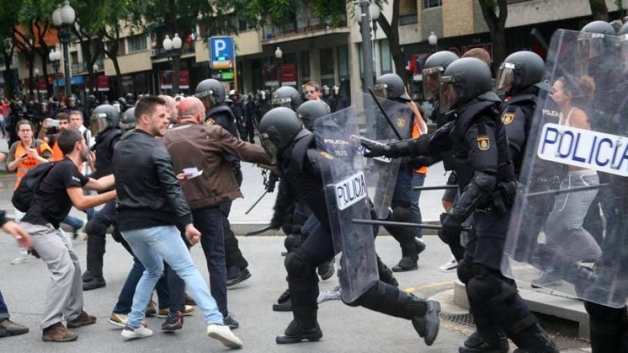 Agentes de la policía nacional intentan retirar a los concentrados en el instituto IES Tarragona el 1-O. FOTO: DT
