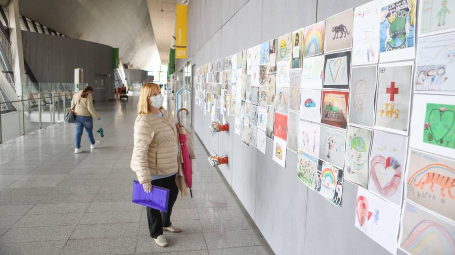 Una mujer se para a ver los dibujos y cartas que llenan las paredes de la entrada del Hospital Sant Joan. FOTO: A.Mariné